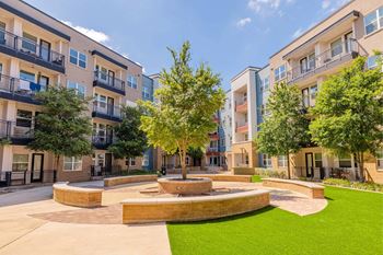 A courtyard with a fountain surrounded by apartment buildings.